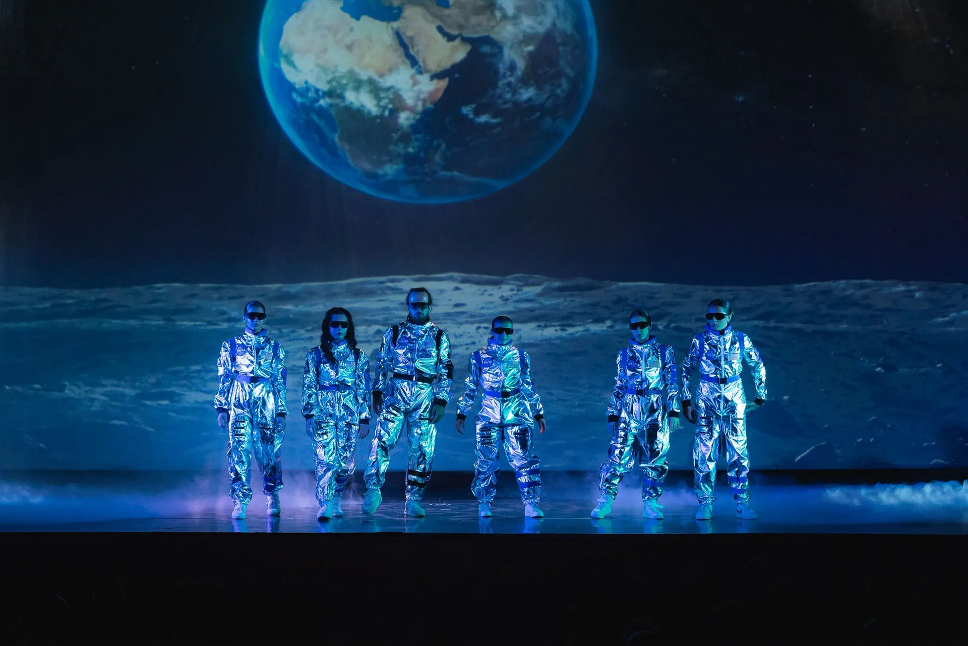 Gruppo di allievi in costume da astronauta durante un numero di danza a tema spaziale, saggio del centro Melody di Conversano